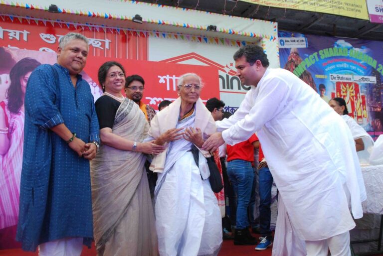 Sundeep Bhutoria with Anand Sahai, Tanusree Shankar felicitating a senior citizen at the Vodafone Maniktalla Chaltabagan Durga Puja